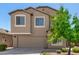 Two-story home featuring neutral stucco, complemented by a lush tree and a convenient two-car garage at 1021 W Vineyard Plains Dr, San Tan Valley, AZ 85143