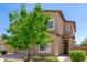 View of a two-story home featuring neutral stucco, complemented by a lush tree and a covered entrance at 1021 W Vineyard Plains Dr, San Tan Valley, AZ 85143