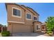 View of a two-story home highlighting the large garage door and a neatly landscaped front yard at 1021 W Vineyard Plains Dr, San Tan Valley, AZ 85143
