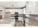 Modern kitchen with stainless appliances, granite countertops and white cabinets, perfect for cooking at 1021 W Vineyard Plains Dr, San Tan Valley, AZ 85143