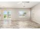 Bright open-concept living room featuring a sliding glass door, enhanced by wood-look tile flooring at 1021 W Vineyard Plains Dr, San Tan Valley, AZ 85143