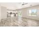 Open-concept living room with wood-look tile flooring, filled with natural light from the sliding glass door at 1021 W Vineyard Plains Dr, San Tan Valley, AZ 85143