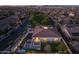 Sunset aerial of a Gathering home with a pool, manicured backyard, and gorgeous landscape lighting at 10511 E Diffraction Ave, Mesa, AZ 85212