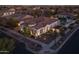 Aerial night view of a landscaped home with a charming tile roof, lovely outdoor lighting, and paver driveway at 10511 E Diffraction Ave, Mesa, AZ 85212