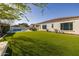 Expansive backyard with lush green grass, a modern pool, outdoor seating, and beautiful landscaping for outdoor enjoyment at 10511 E Diffraction Ave, Mesa, AZ 85212
