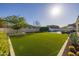 Expansive backyard featuring lush green lawn, refreshing pool, stylish lounge area, and manicured landscaping at 10511 E Diffraction Ave, Mesa, AZ 85212