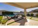 Beautiful backyard with a covered patio, pool with waterfall feature, and an outdoor seating area with fire pit at 10511 E Diffraction Ave, Mesa, AZ 85212