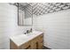 Chic powder room with modern lighting and white shiplap walls contrasting the wood vanity and patterned wallpaper at 10511 E Diffraction Ave, Mesa, AZ 85212
