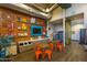 Interior view of common area with vintage decor, tables, seating, vending machines and television at 10511 E Diffraction Ave, Mesa, AZ 85212