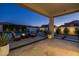 Relaxing covered patio with comfortable seating, fire pit, and views of the backyard pool and lush landscaping at 10511 E Diffraction Ave, Mesa, AZ 85212