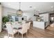Open concept dining room flows into the kitchen and living room with wood floors at 10511 E Diffraction Ave, Mesa, AZ 85212