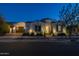Charming home exterior illuminated at twilight with manicured landscaping and a paver driveway at 10511 E Diffraction Ave, Mesa, AZ 85212
