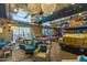 Open game room with colorful decor, foosball table, pool table and vintage painted bus turned into sitting area at 10511 E Diffraction Ave, Mesa, AZ 85212