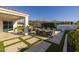 Inviting backyard patio featuring travertine tile, a dining table with umbrella, and a built-in outdoor kitchen at 10511 E Diffraction Ave, Mesa, AZ 85212