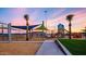 Colorful playground with slides and swings, shaded by palm trees against a beautiful sunset at 10511 E Diffraction Ave, Mesa, AZ 85212
