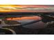 An aerial view of a community pond reflects the setting sun in this vibrant community at 10511 E Diffraction Ave, Mesa, AZ 85212