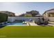 Picturesque backyard oasis featuring a modern pool with waterfall feature, lounge chairs, and outdoor dining area at 10511 E Diffraction Ave, Mesa, AZ 85212