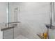 Walk-in shower features a built-in shelf and elegant marble-style tiling at 10511 E Diffraction Ave, Mesa, AZ 85212