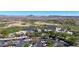 Aerial view of a modern clubhouse complex with ample parking, surrounded by lush green golf course fairways and desert landscape at 12439 W Yellow Bird Ln, Peoria, AZ 85383