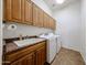 Functional laundry room with built-in cabinets, sink, washer, and dryer, perfect for everyday chores at 12439 W Yellow Bird Ln, Peoria, AZ 85383
