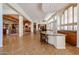 Open concept living room with fireplace, bar, plantation shutters, tile floors, and decorative pillars at 12439 W Yellow Bird Ln, Peoria, AZ 85383