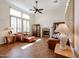Living room featuring a fireplace, ceiling fan, plantation shutters, tile floors, and comfortable seating at 12439 W Yellow Bird Ln, Peoria, AZ 85383