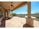 Relaxing covered patio with ceiling fans, outdoor seating, and a view of the landscaped backyard at 12439 W Yellow Bird Ln, Peoria, AZ 85383
