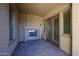 Covered patio featuring a stone fireplace, access door, and brick-paved flooring at 12439 W Yellow Bird Ln, Peoria, AZ 85383