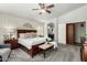 A spacious main bedroom featuring a dark wood bed frame, neutral color palette, and ensuite bathroom access at 12749 W Sheridan St, Avondale, AZ 85392