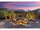 Backyard waterfall feature with lighting, palm trees, and rock landscaping at 13065 W Lucia Dr, Peoria, AZ 85383