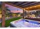 Relaxing backyard with hot tub, pergola, outdoor kitchen, and lush landscaping at 13065 W Lucia Dr, Peoria, AZ 85383