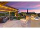 Gorgeous outdoor area featuring pergola, string lights, outdoor kitchen, and well-manicured lawn at 13065 W Lucia Dr, Peoria, AZ 85383