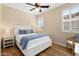 Bright bedroom featuring hardwood floors, shutters on windows, and a white bed with blue accents at 13065 W Lucia Dr, Peoria, AZ 85383