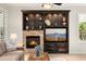 Bright living room featuring a stone fireplace, built-in shelves, and a large window at 13065 W Lucia Dr, Peoria, AZ 85383