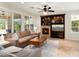 Cozy living room featuring a stone fireplace, built-in shelves, and large windows at 13065 W Lucia Dr, Peoria, AZ 85383