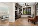 Office features built-in bookshelves, a cozy sitting area, and natural light from shuttered windows at 13065 W Lucia Dr, Peoria, AZ 85383