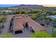 A beautiful aerial view of this desert home shows the tile roof, garages, and mountain views at 13627 E Monument Dr, Scottsdale, AZ 85262