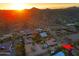 Expansive aerial view showcasing a desert home with a pool and mountain views at sunset at 13627 E Monument Dr, Scottsdale, AZ 85262