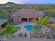 Breathtaking aerial view of a luxury home featuring a pool, spa, and rooftop deck against a scenic desert backdrop at 13627 E Monument Dr, Scottsdale, AZ 85262
