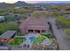 Aerial image of the private backyard featuring a pool, hot tub, lush landscaping, and sunset views at 13627 E Monument Dr, Scottsdale, AZ 85262