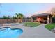 Backyard featuring a luxurious pool, outdoor kitchen and entertainment area, and lush green lawn at 13627 E Monument Dr, Scottsdale, AZ 85262