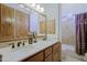 Bright bathroom featuring a double vanity, custom mirrors, and a shower with a decorative curtain at 13627 E Monument Dr, Scottsdale, AZ 85262