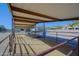 Covered horse shelter and stalls featuring metal beams and fencing on a sunny day at 13627 E Monument Dr, Scottsdale, AZ 85262