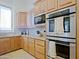 Kitchen detail featuring stainless steel appliances, stone backsplash, and wood cabinets at 13627 E Monument Dr, Scottsdale, AZ 85262