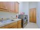 Convenient laundry room equipped with modern washer and dryer, cabinetry and sink at 13627 E Monument Dr, Scottsdale, AZ 85262