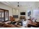 Inviting living room with stone fireplace, comfortable seating, and natural light from large windows at 13627 E Monument Dr, Scottsdale, AZ 85262