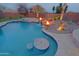 Inviting pool featuring a swim-up table, spa, and a captivating rock waterfall with fire bowls creating a luxurious outdoor oasis at 13627 E Monument Dr, Scottsdale, AZ 85262