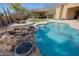 Backyard pool with rock waterfall feature, fire bowls and built in sun-shelf at 13627 E Monument Dr, Scottsdale, AZ 85262