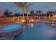 Beautiful in-ground pool featuring waterfall, spa, and adjacent fire bowls. surrounded by patio and landscaping at 13627 E Monument Dr, Scottsdale, AZ 85262