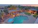 Aerial view of a backyard featuring a pool, spa, waterfall, fire bowls, and outdoor kitchen with bar seating at 13627 E Monument Dr, Scottsdale, AZ 85262